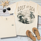 Beige t-shirt with 'Lost at Sea' design, sunglasses, starfish, and flip-flops on a wooden surface.
